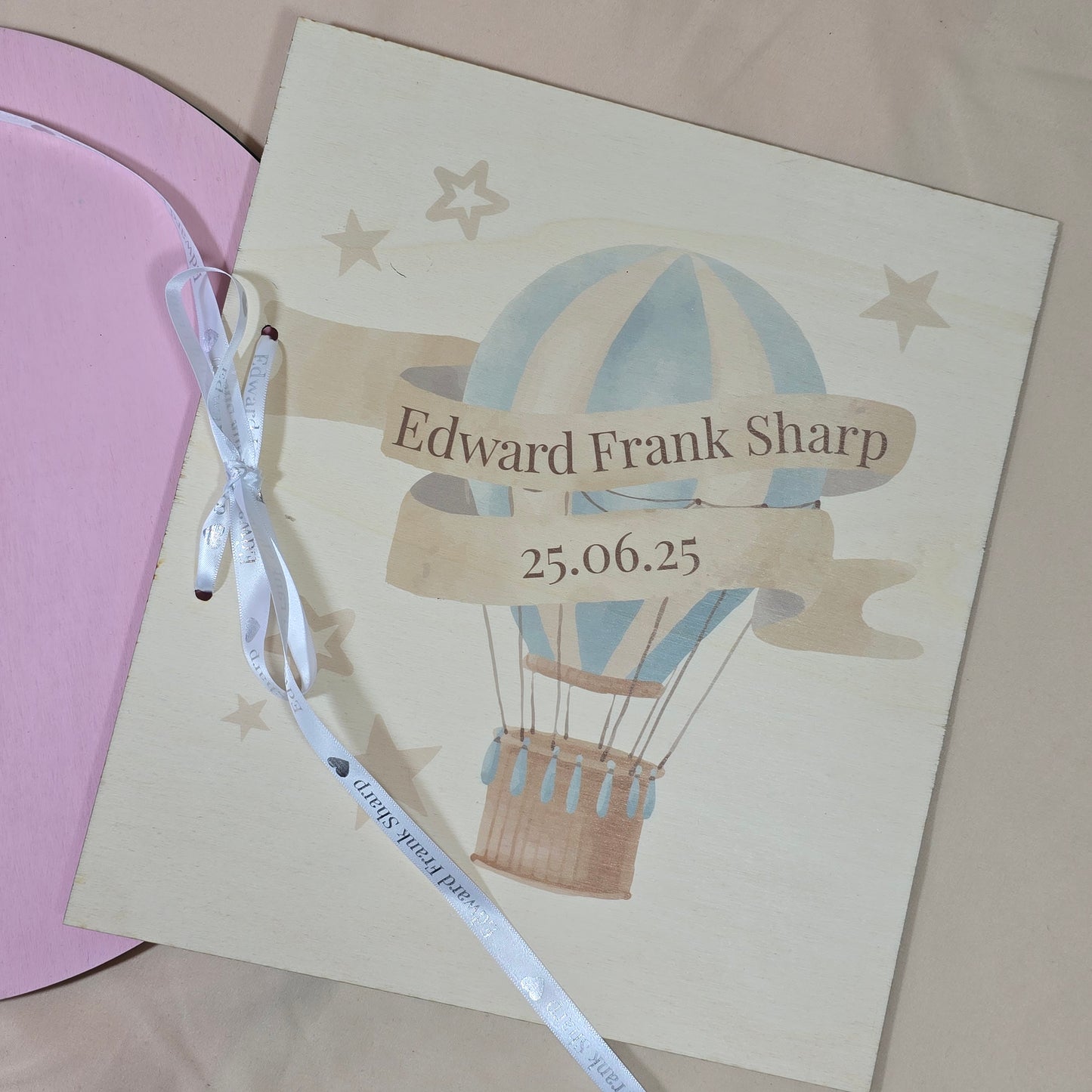 Personalized card with hot air balloon design and text on a pink surface