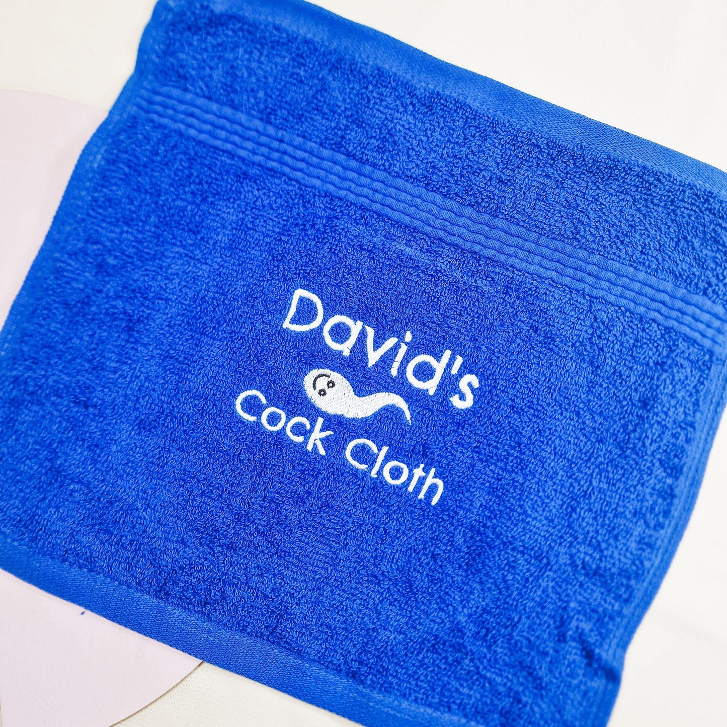 A flannel with the embroidered text "Name's Cock Cloth." Customisable with names, this funny flannel is a unique sex gift or playful present.