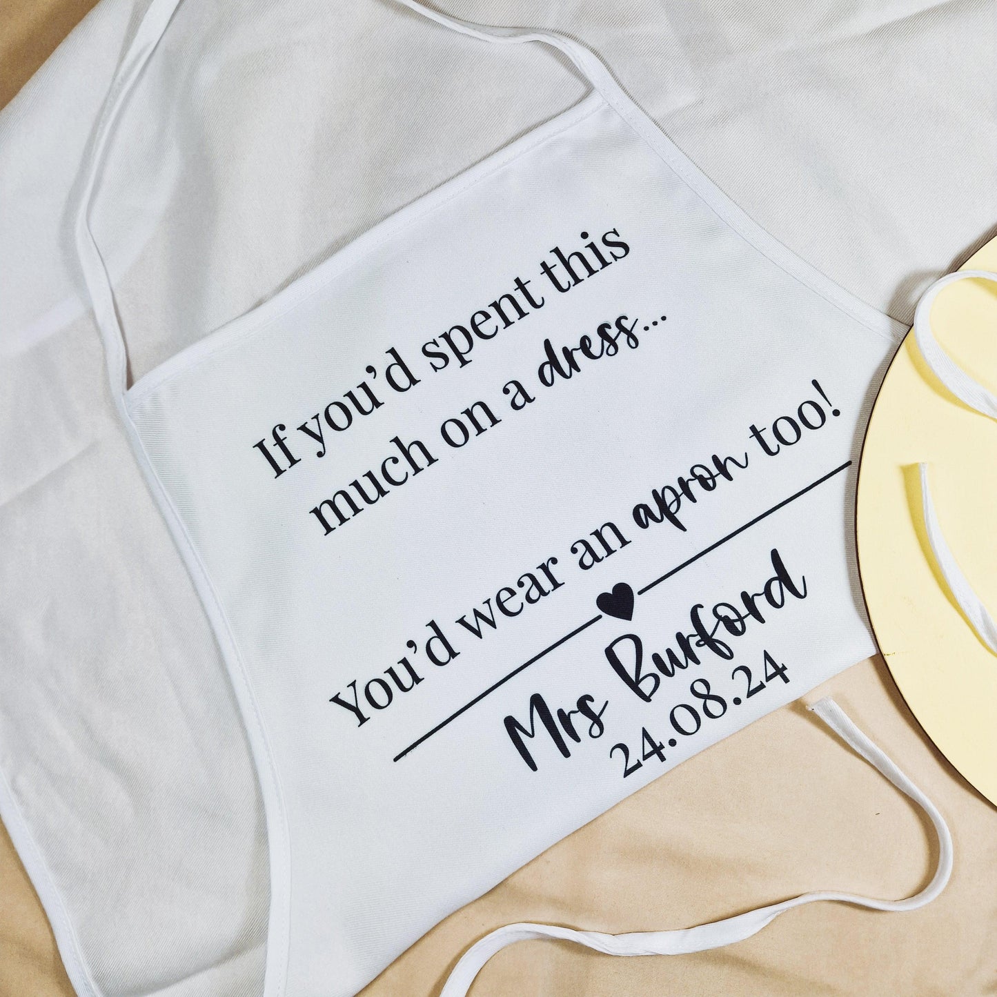 Personalised wedding dress apron with the text "If you spent this much on a dress, you'd wear an apron too!" customised with the bride's name and wedding date.
