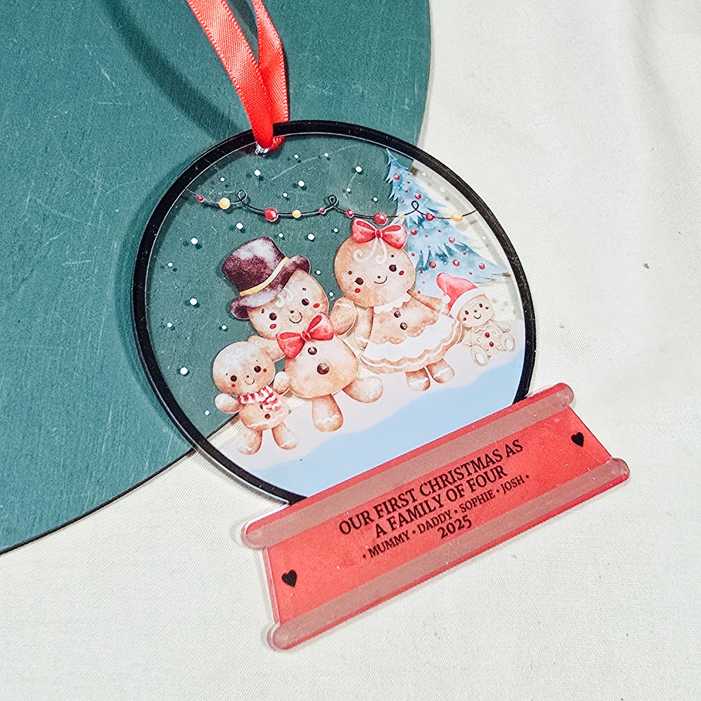 Personalised acrylic Christmas snowglobe decoration with gingerbread family, “Our First Christmas as a Family of Four,” custom names and year