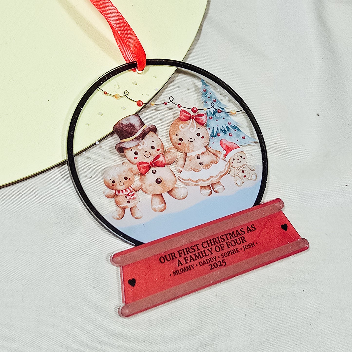 Personalised acrylic Christmas snowglobe decoration with gingerbread family, “Our First Christmas as a Family of Four,” custom names and year