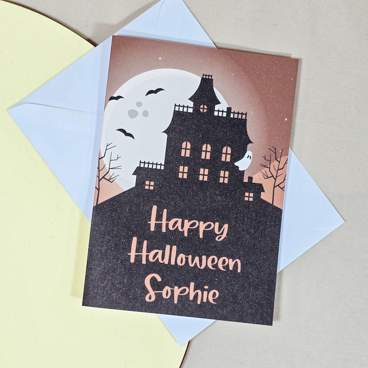 Personalised Halloween card with a haunted house design, customisable with the recipient's name, and an option to add an inside message.