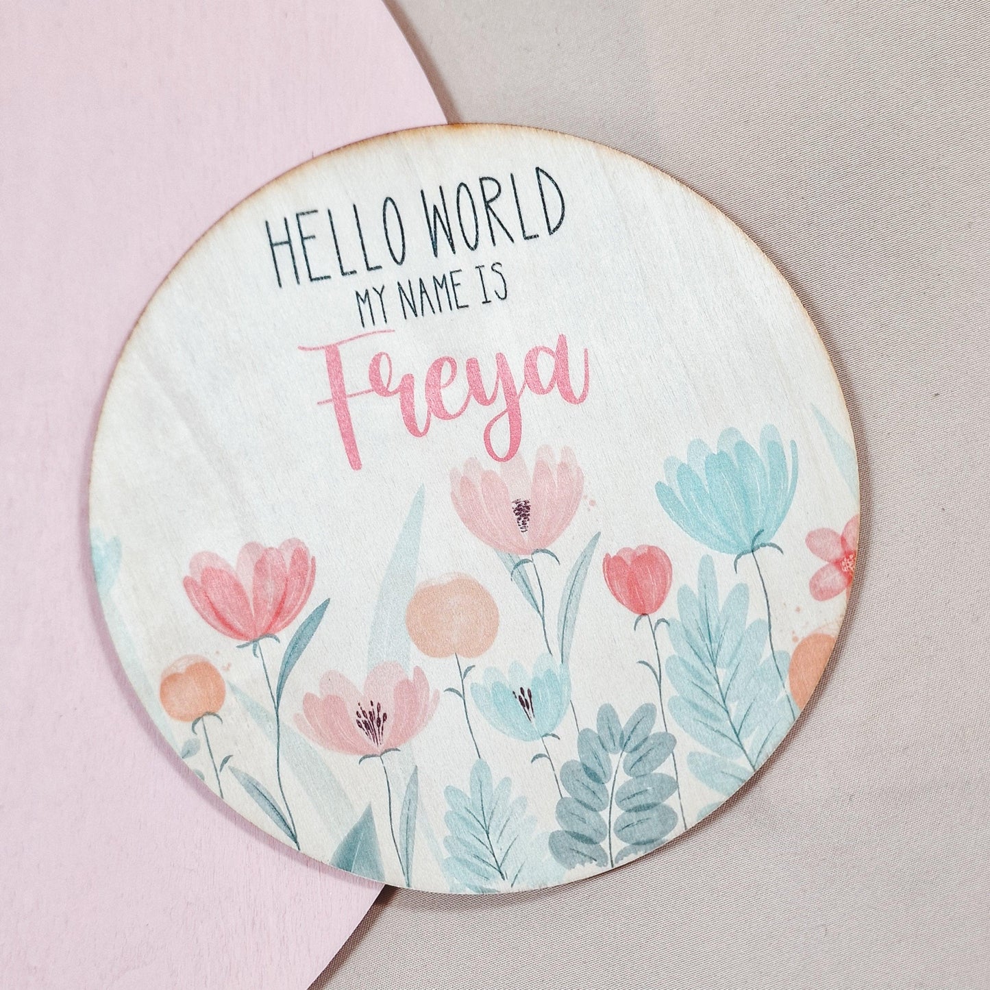 a wooden circular sign with 'hello world my name is' written on
