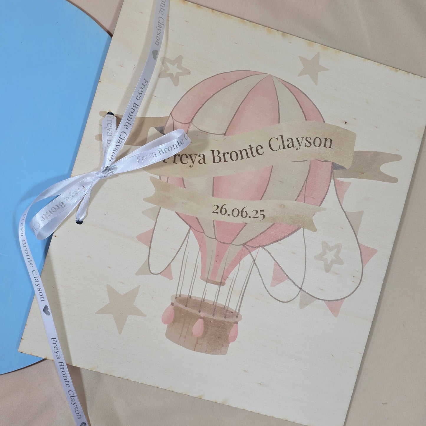 Invitation card with hot air balloon design and ribbon on a blue and beige background
