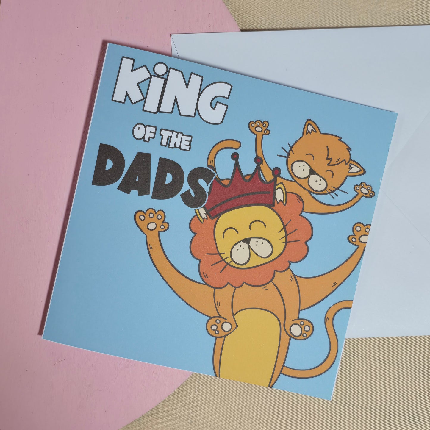 Card with a lion wearing a crown and text 'King of the Dads' on a pink and beige background