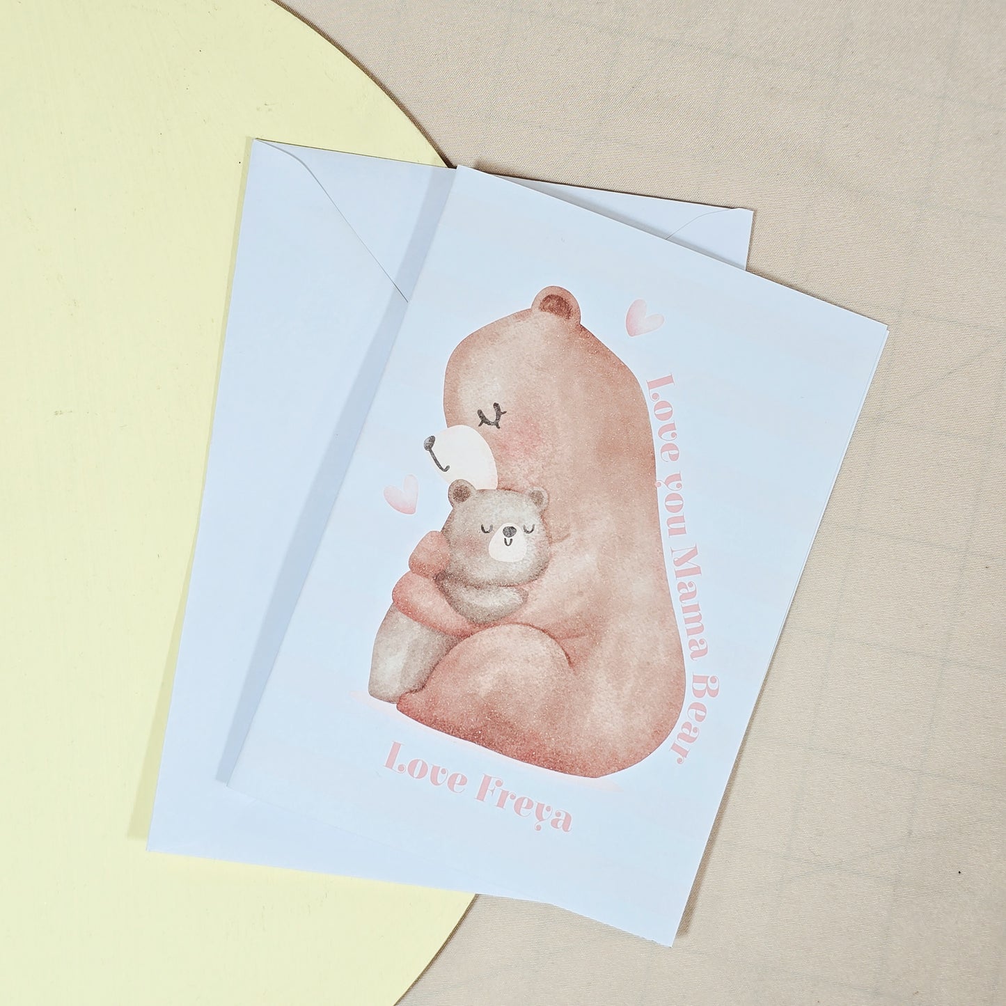 A6 greeting card featuring a mama bear hugging a baby bear, with "Love You Mama Bear" written above and a personalised name below. Comes with a white envelope.
