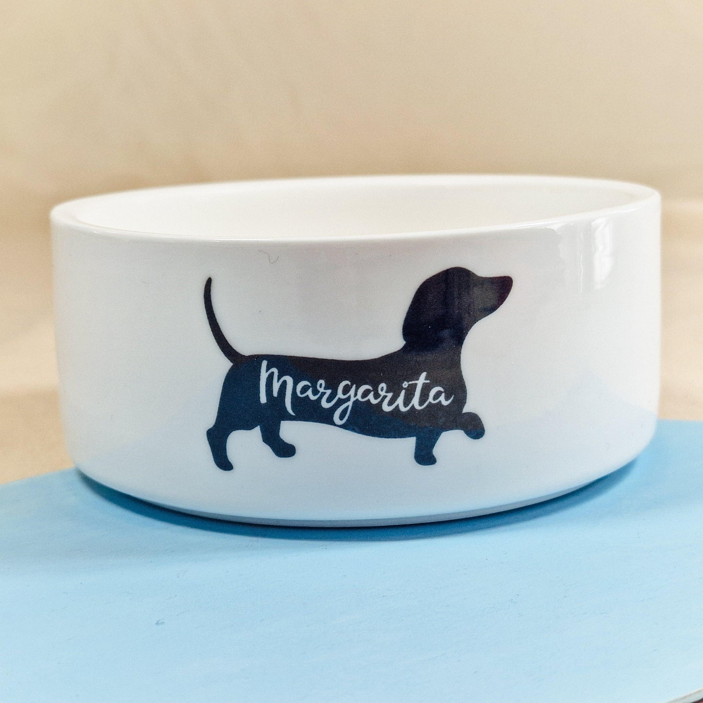 Personalised pet bowl featuring a dachshund silhouette with the dog's name printed inside. Available in small, medium, and large sizes. Perfect for dachshund lovers."
