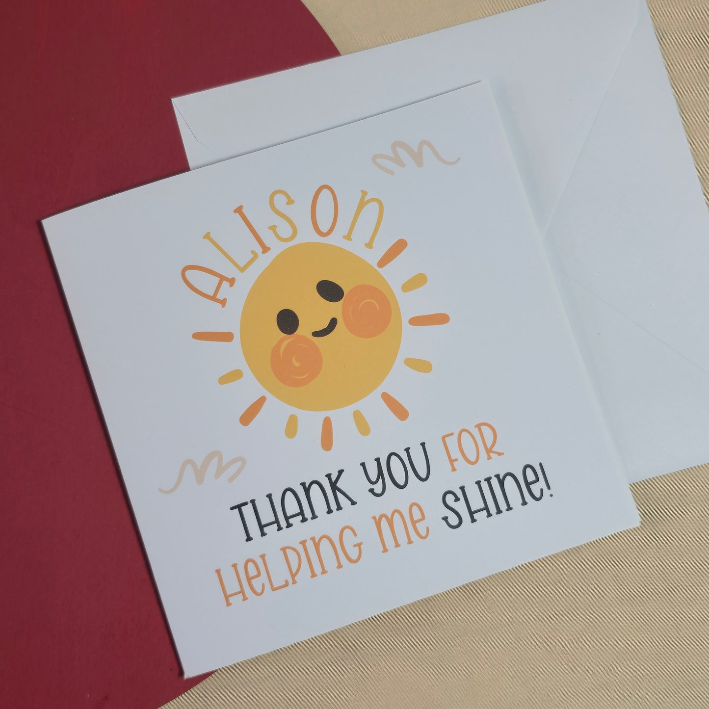 Card with a sun illustration and text on a red surface