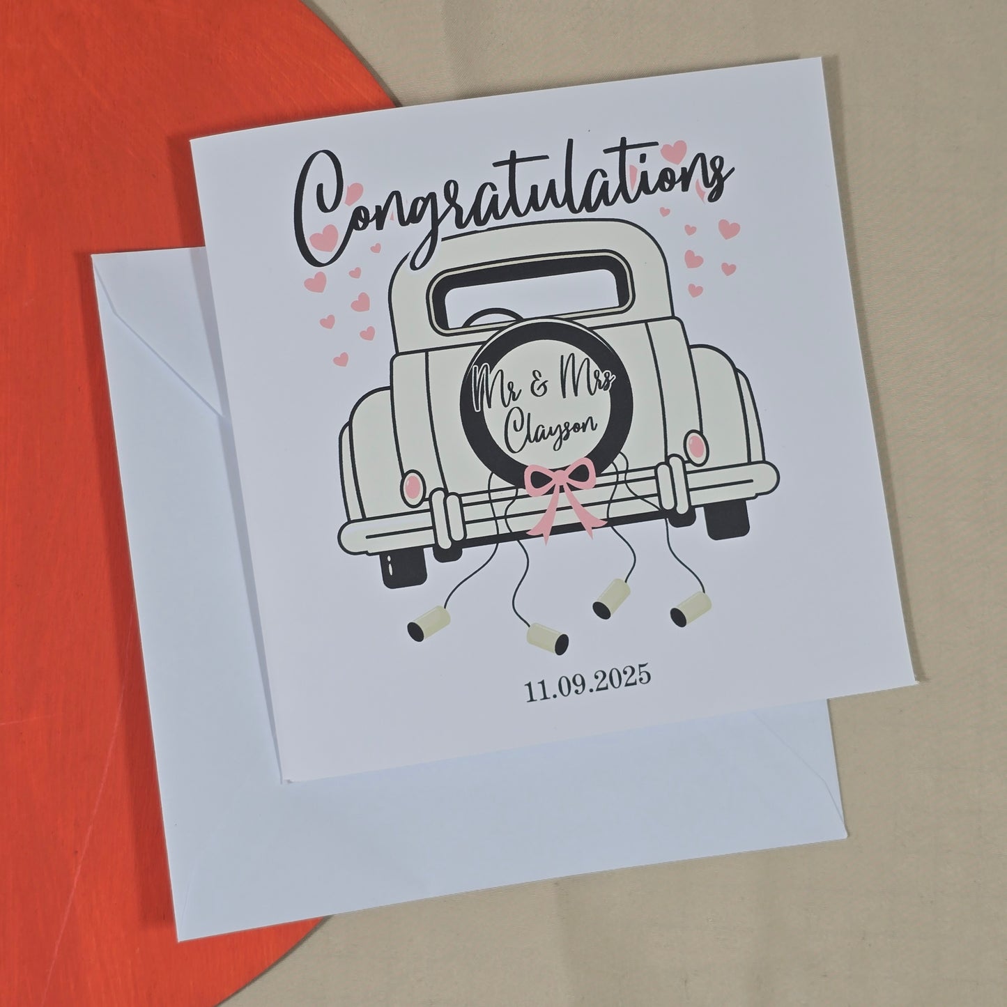 Wedding card with a vintage car illustration and personalized text on a red and beige background