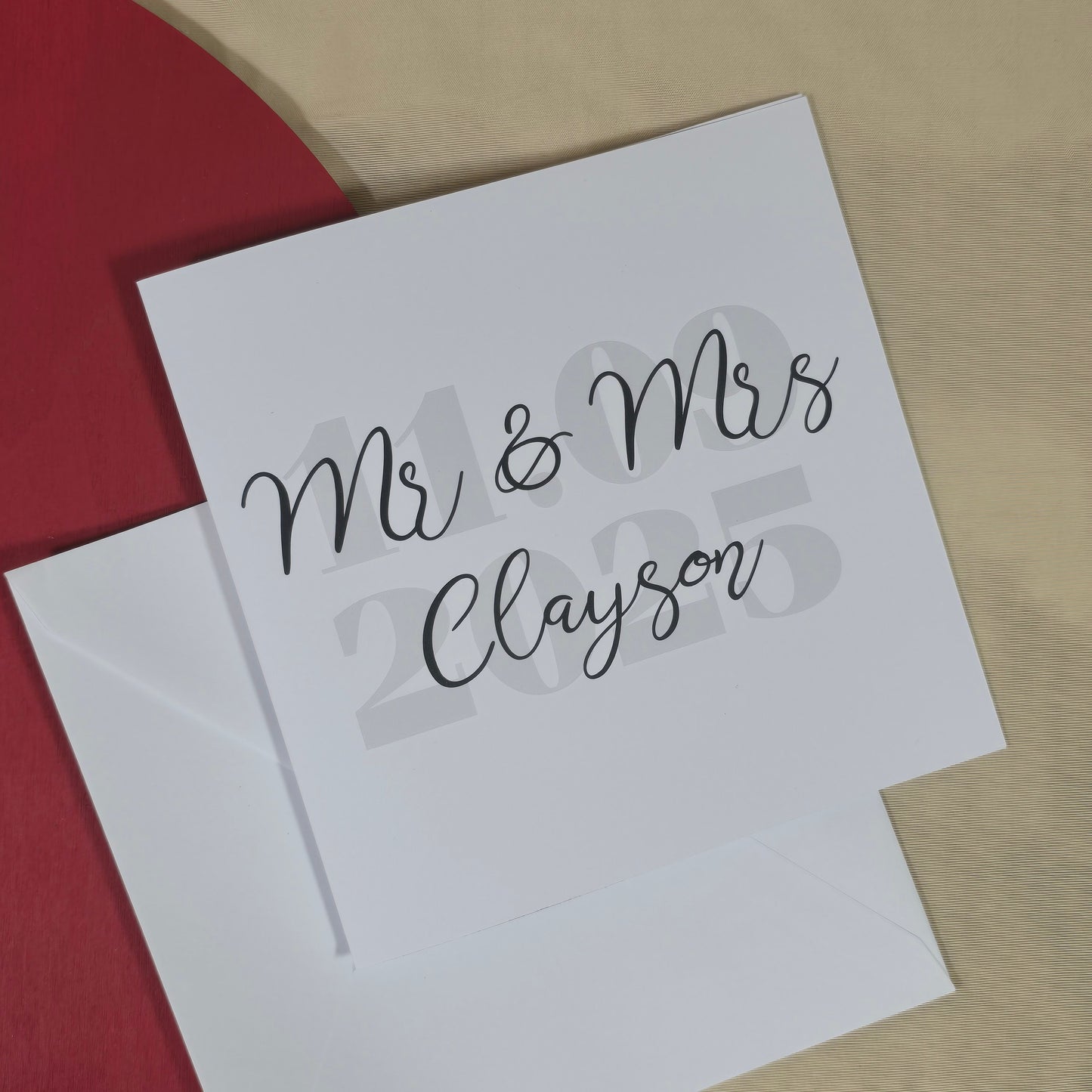 White card with 'Mr & Mrs Clayton' text on a red and beige background