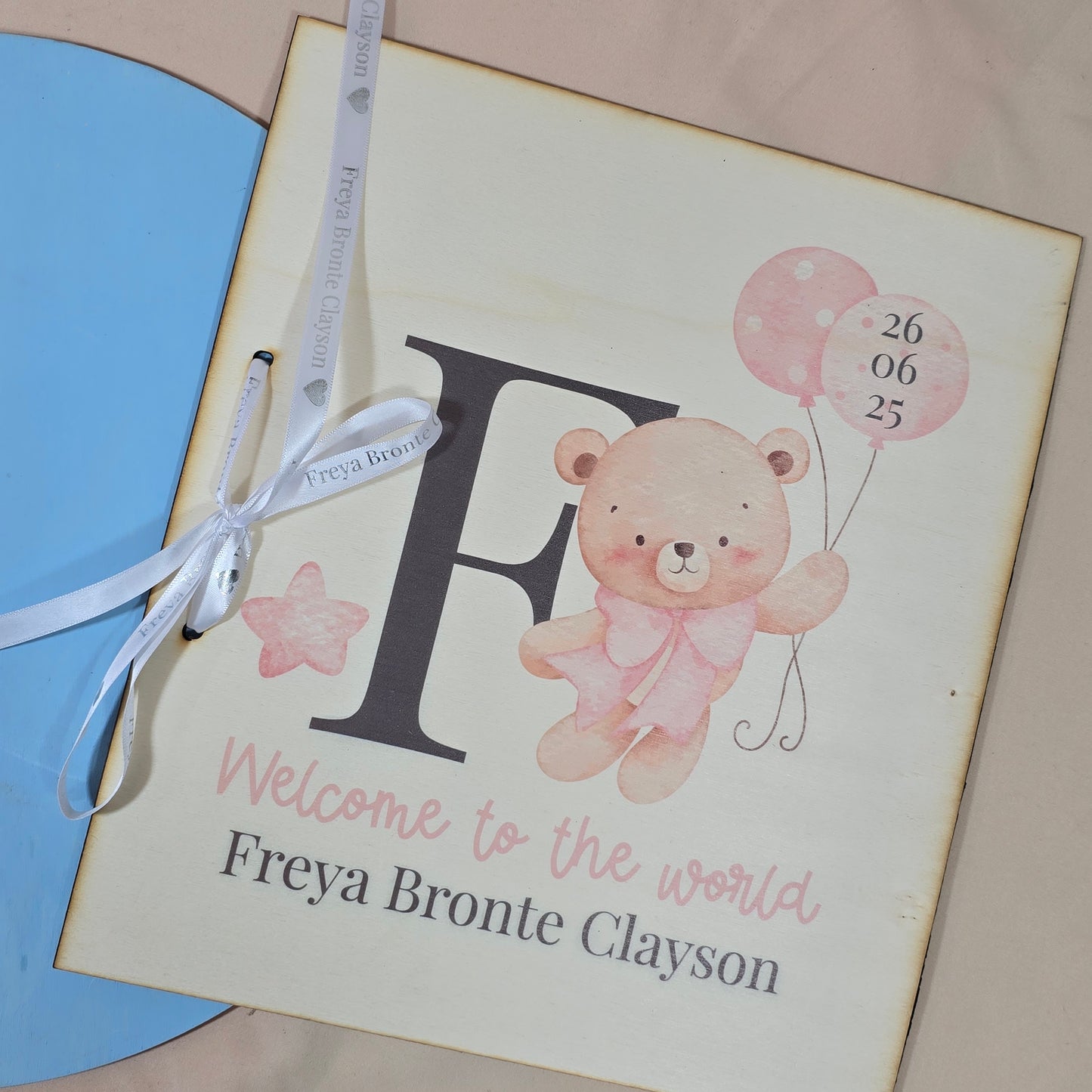 Baby shower invitation with teddy bear and balloons on a pink background