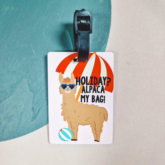 a luggage tag with an alpaca wearing sunglasses on, with a beach ball and parasol