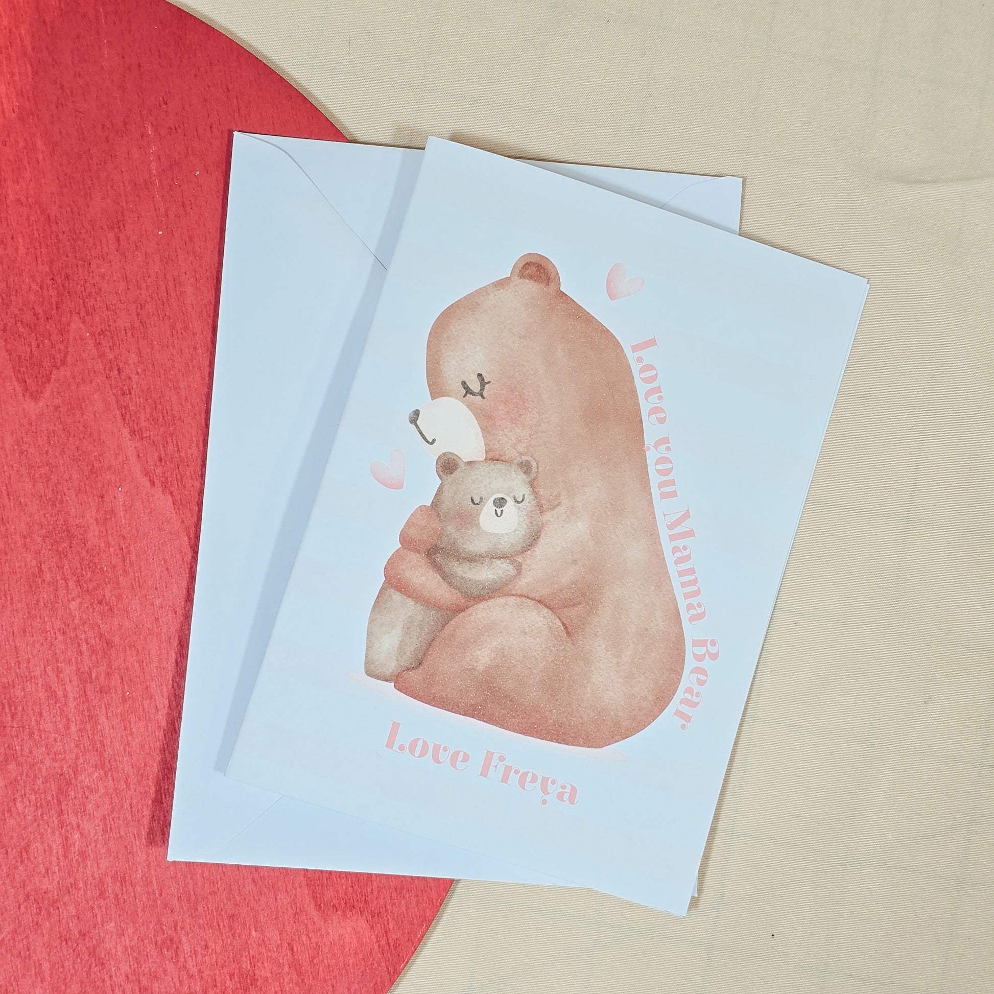 A6 greeting card featuring a mama bear hugging a baby bear, with "Love You Mama Bear" written above and a personalised name below. Comes with a white envelope.


