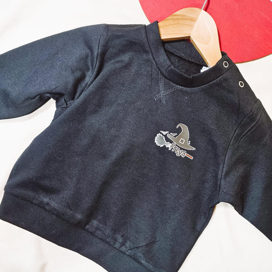 Black kids jumper featuring a witches hat and broomstick design, personalised with the child's name.