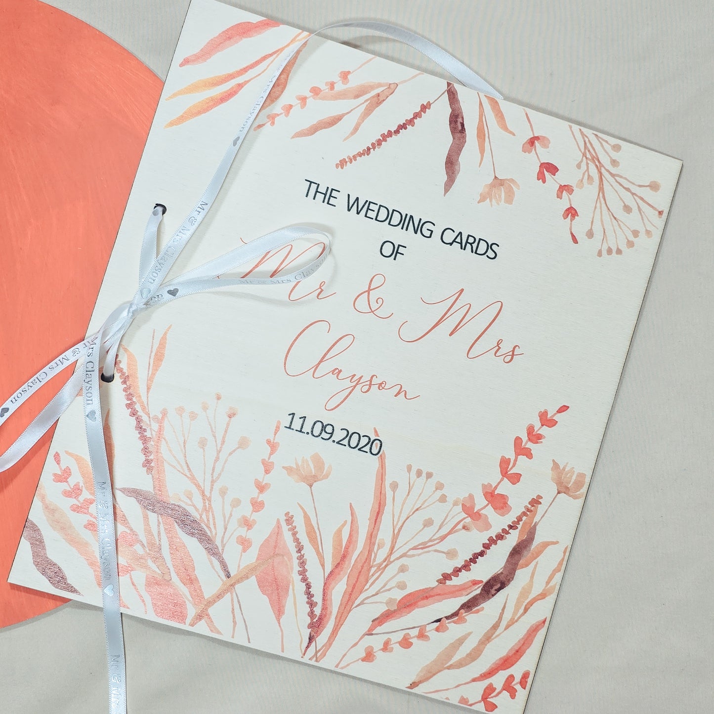 Wedding card with floral design and ribbon on a light background