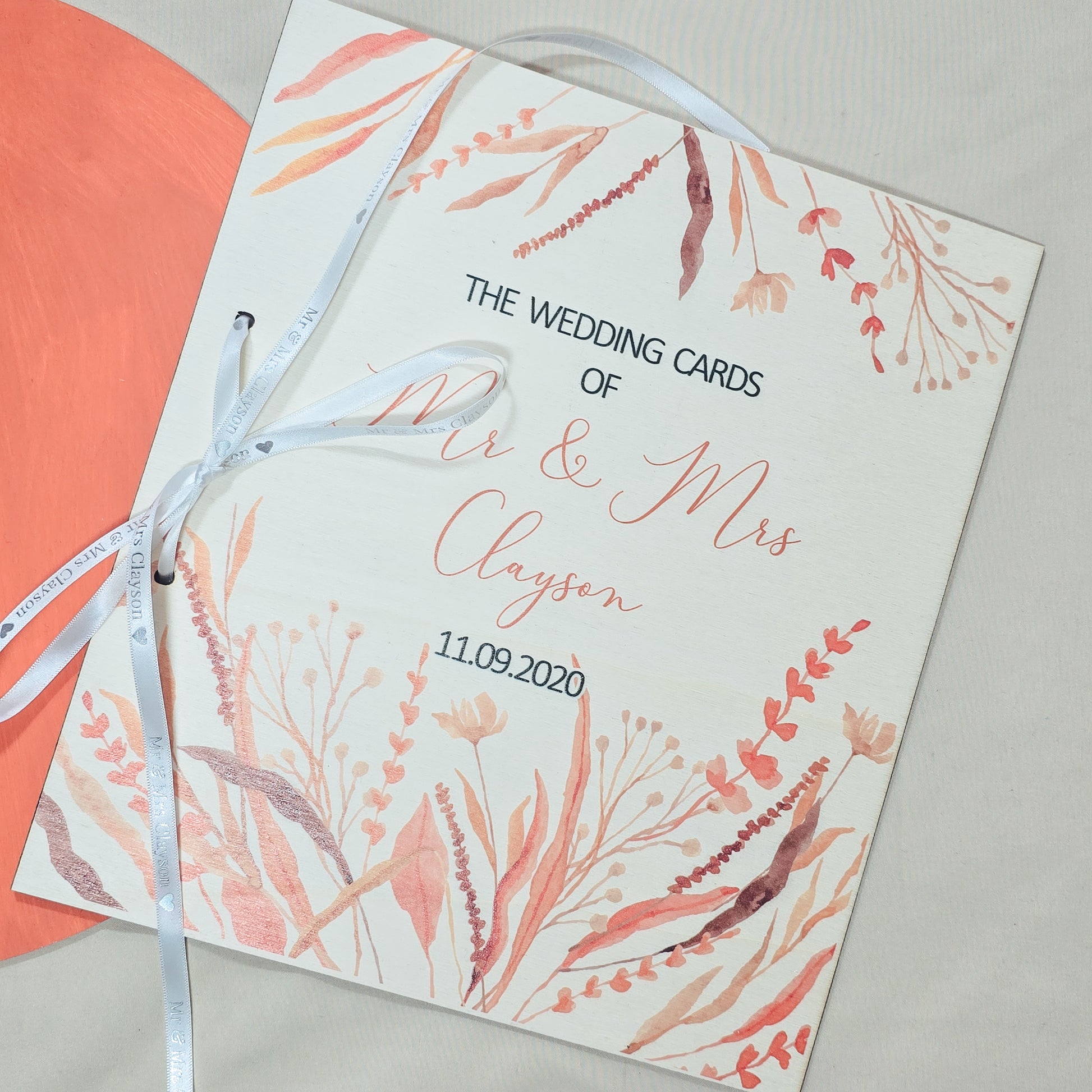 Wedding card with floral design and ribbon on a light background