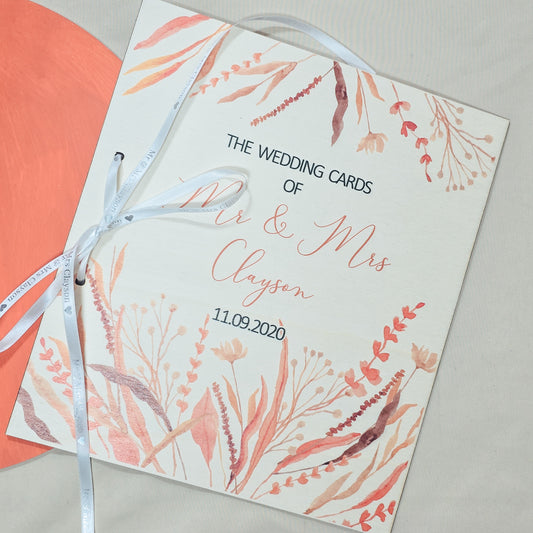 Wedding card with floral design and ribbon on a light background