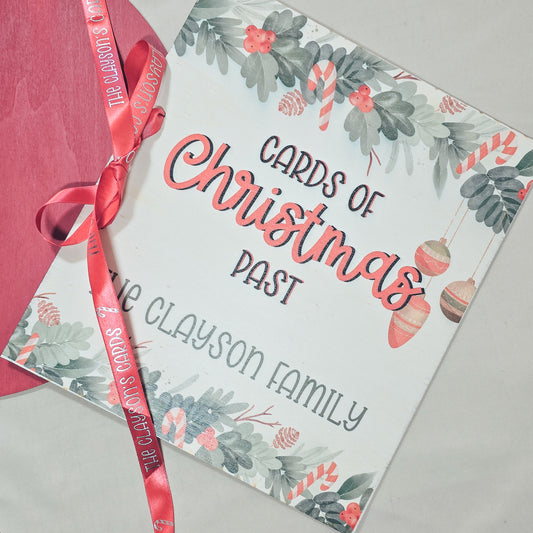 Christmas-themed card book with decorative ribbon on a gray surface