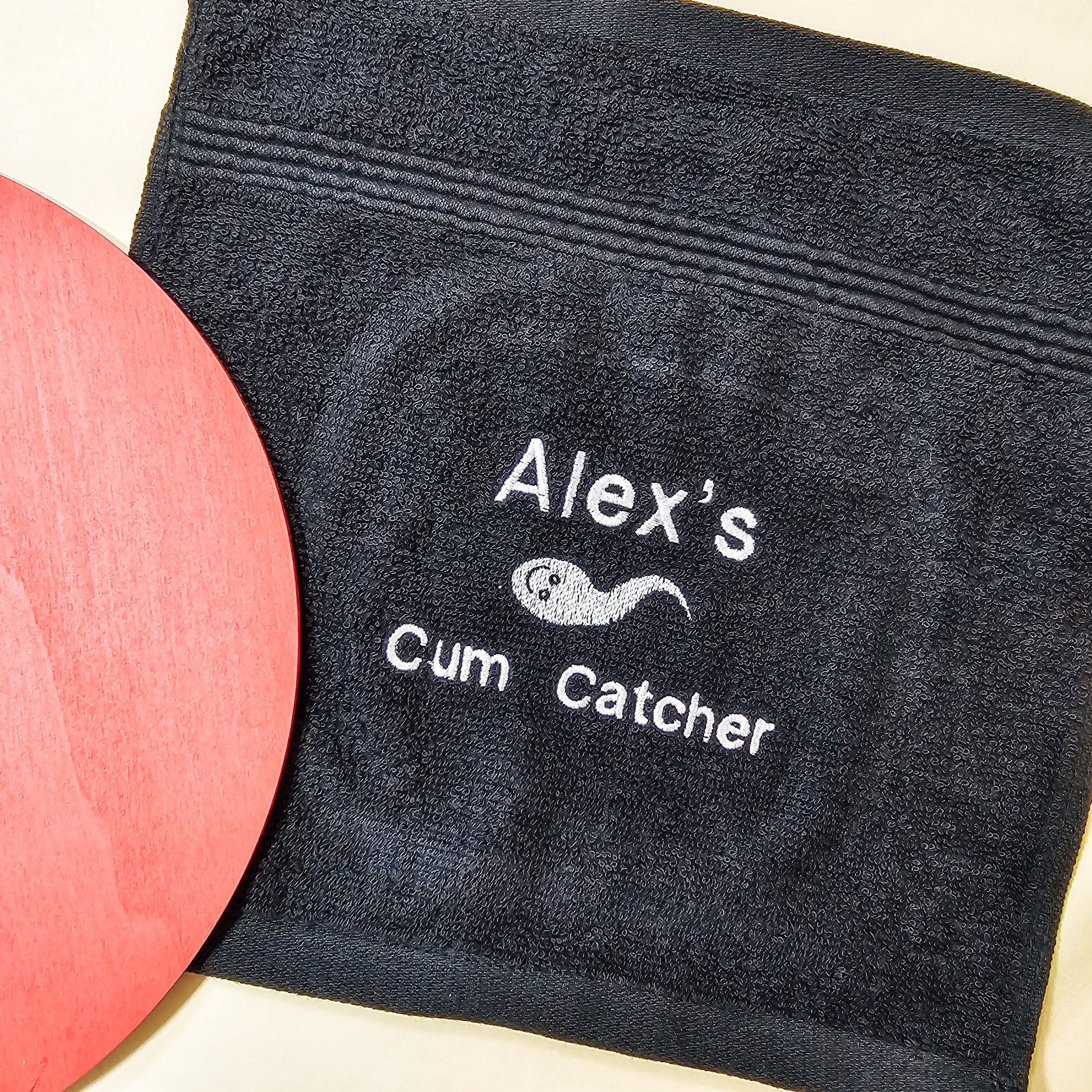 Personalised cum catcher towel, soft black fabric with a cheeky custom name, perfect for a funny, adult-themed gag gift or novelty present.






