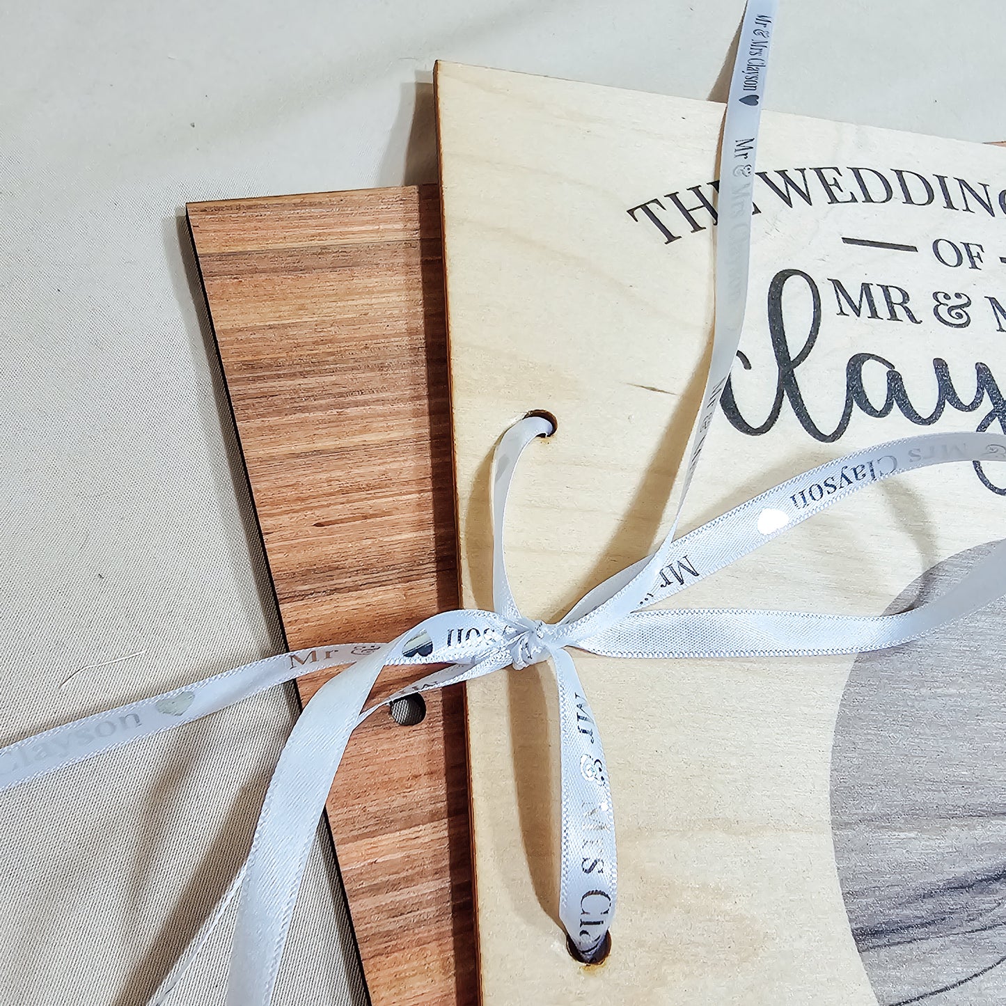 A personalised wedding card book with "The Wedding Cards of Mr & Mrs [Name]" and a wedding photo printed on the wooden cover, tied with a ribbon, perfect for storing special cards.

