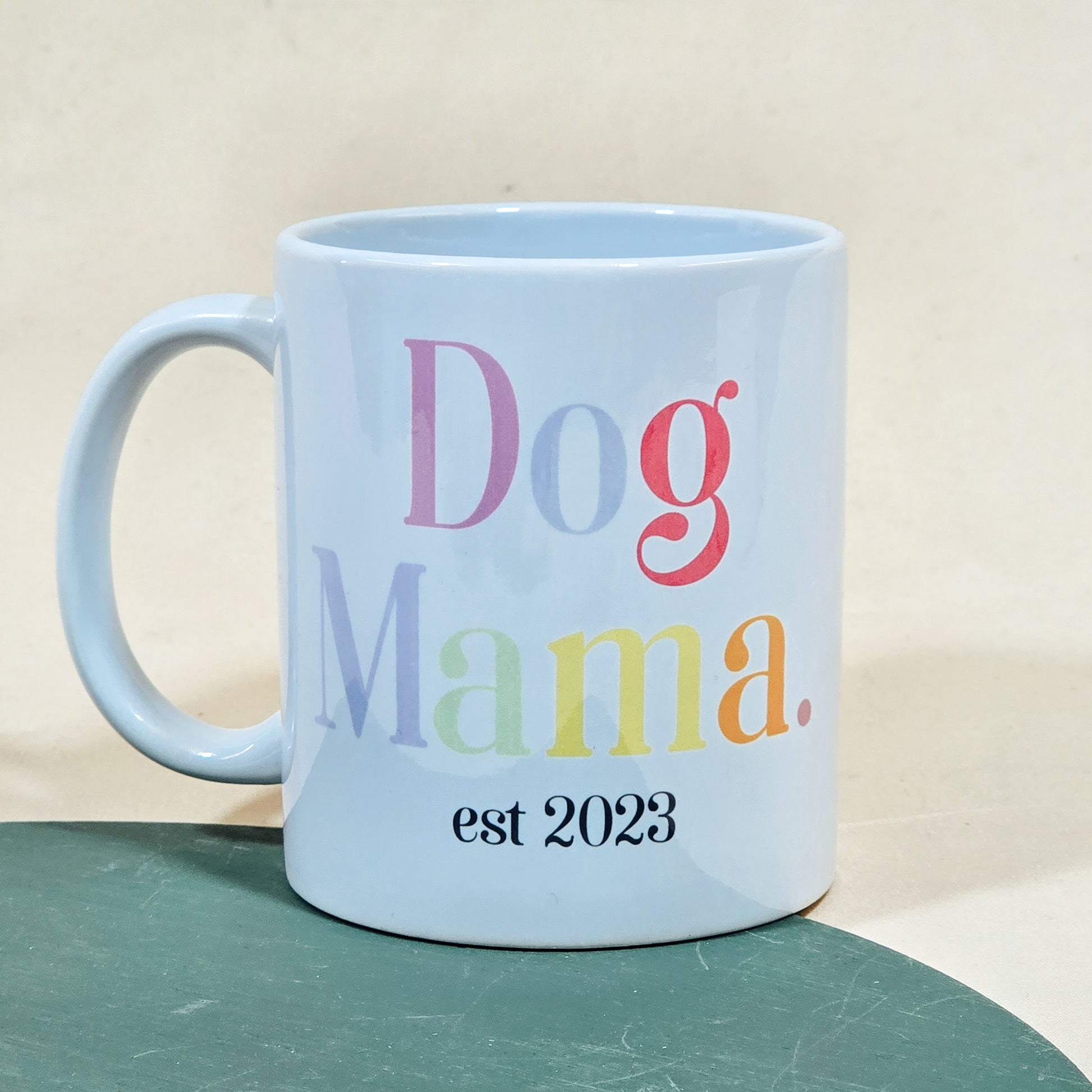 A white ceramic mug with "Dog Mama Est [Date]" in elegant script, available with a matching pet bowl in various sizes.

