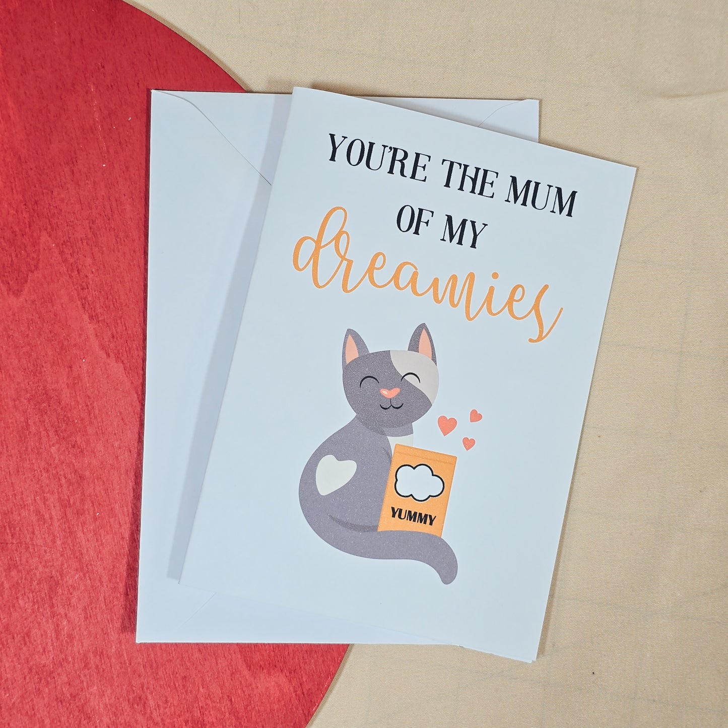 A6 Mother’s Day card featuring a cute cat holding Dreamies treats with the text “You're The Mum of My Dreamies.” Comes with a white envelope.







