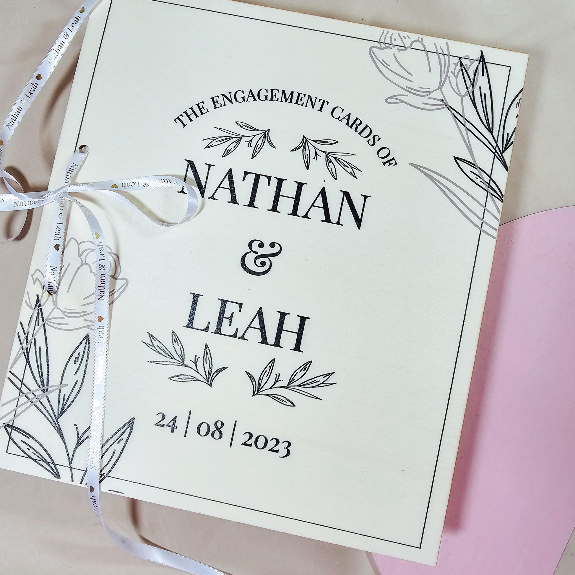 Personalised engagement card book featuring the names [Name & Name] and engagement date.
