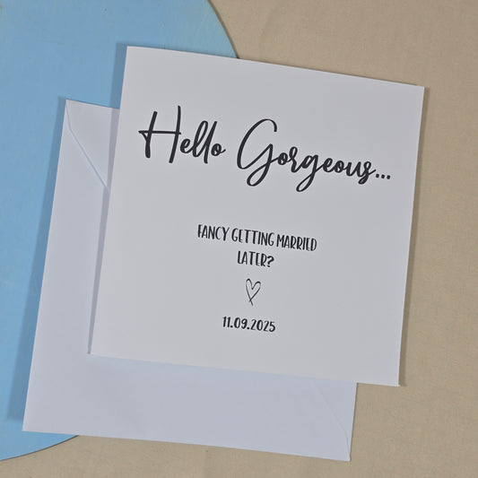 Square wedding day card with the phrase “Hello gorgeous, fancy getting married later?” and a personalised wedding date underneath.

