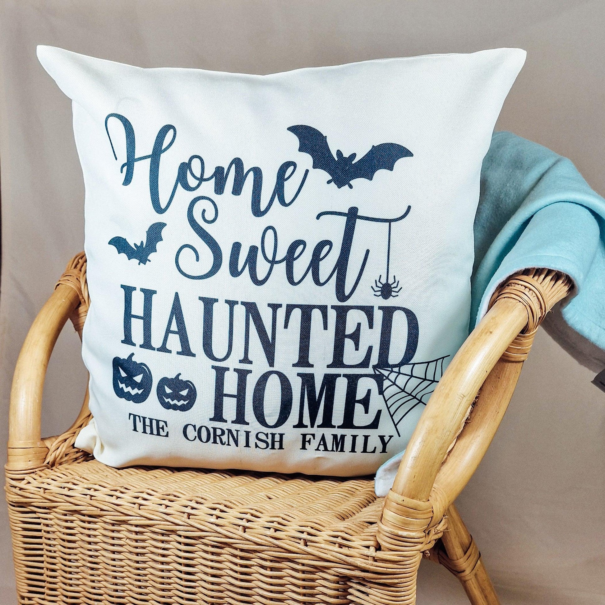 40x40cm cushion cover with "Home Sweet Haunted Home" and family name, featuring Halloween-themed designs like bats, pumpkins, and spiders. Perfect for festive Halloween decor.