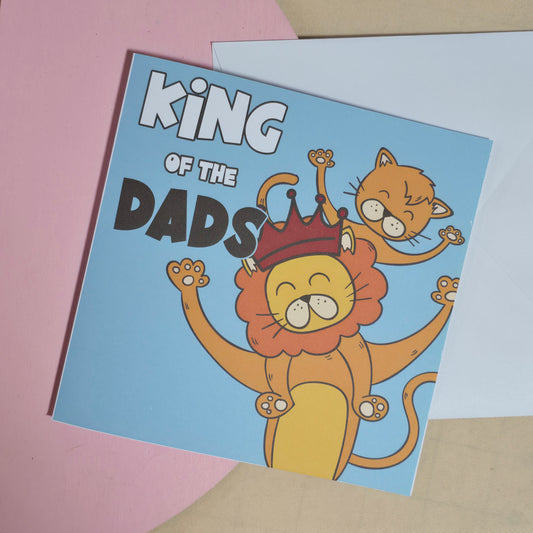 Card with a lion wearing a crown and text 'King of the Dads' on a pink and beige background