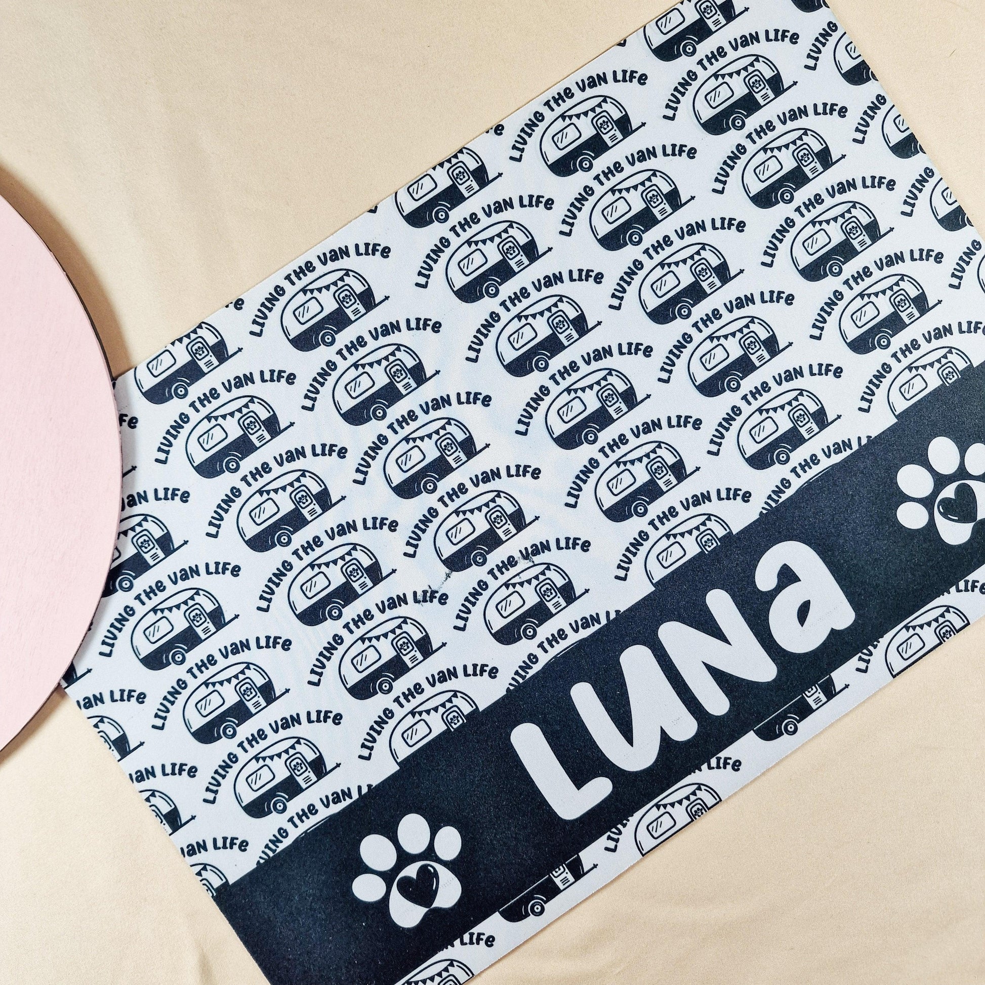 Personalised pet mat with 'Living the Van Life' and a caravan design. Features non-slip backing and custom name, size 41x27cm. Matching pet bowls available in small (12cm), medium (15cm), and large (18cm).