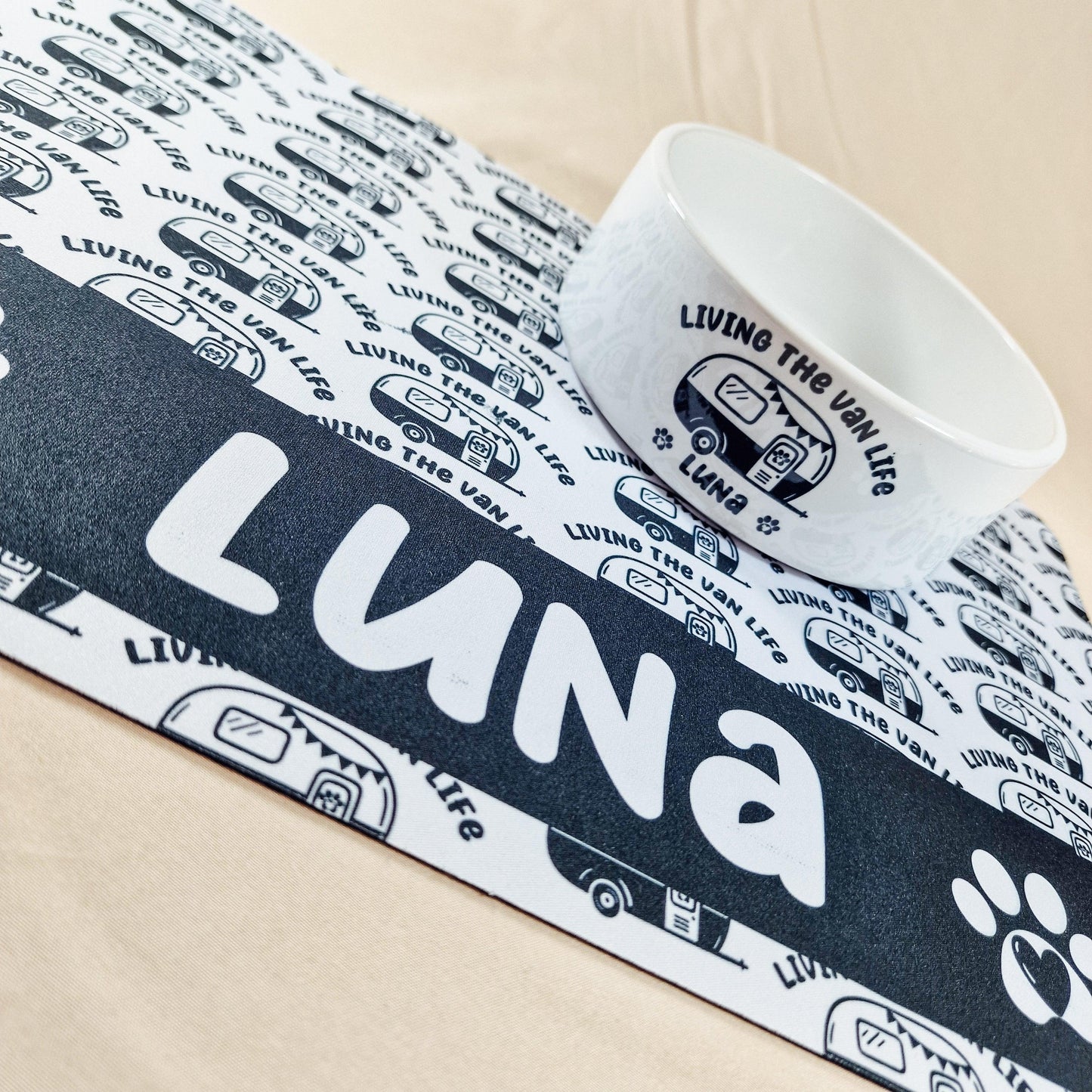 Personalised pet mat with 'Living the Van Life' and a caravan design. Features non-slip backing and custom name, size 41x27cm. Matching pet bowls available in small (12cm), medium (15cm), and large (18cm).