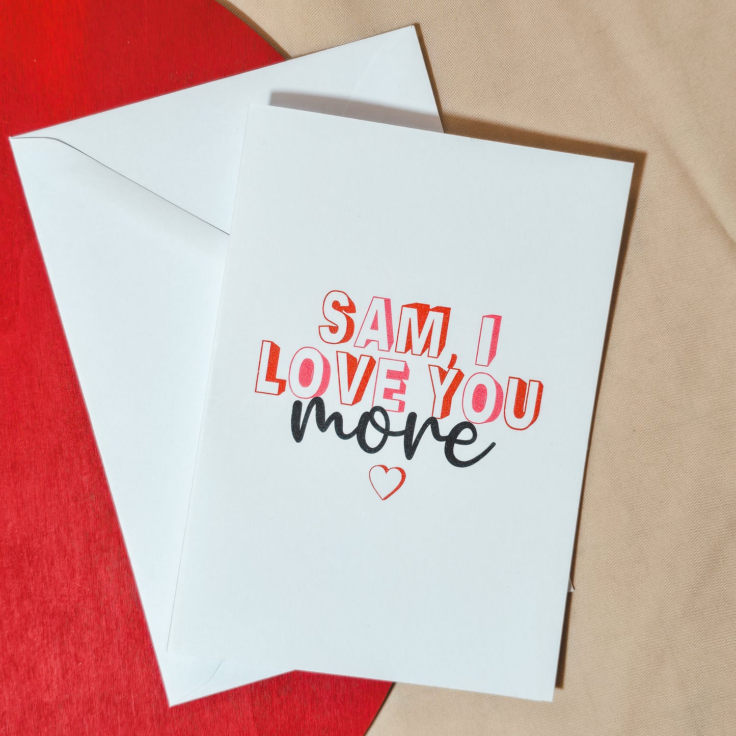 Personalised A6 card with the text "[Name] I love you more" in a romantic font, ideal for Valentine’s Day, anniversaries, or as a thoughtful gesture. Comes with a white envelope.
