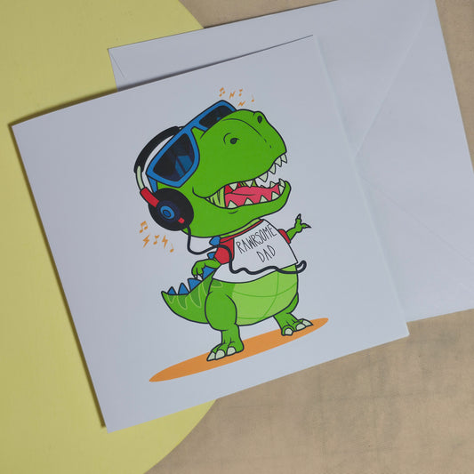 A square 15x15cm card with a cute cartoon dinosaur and the words "Rawrsome Dad" in bold playful font.