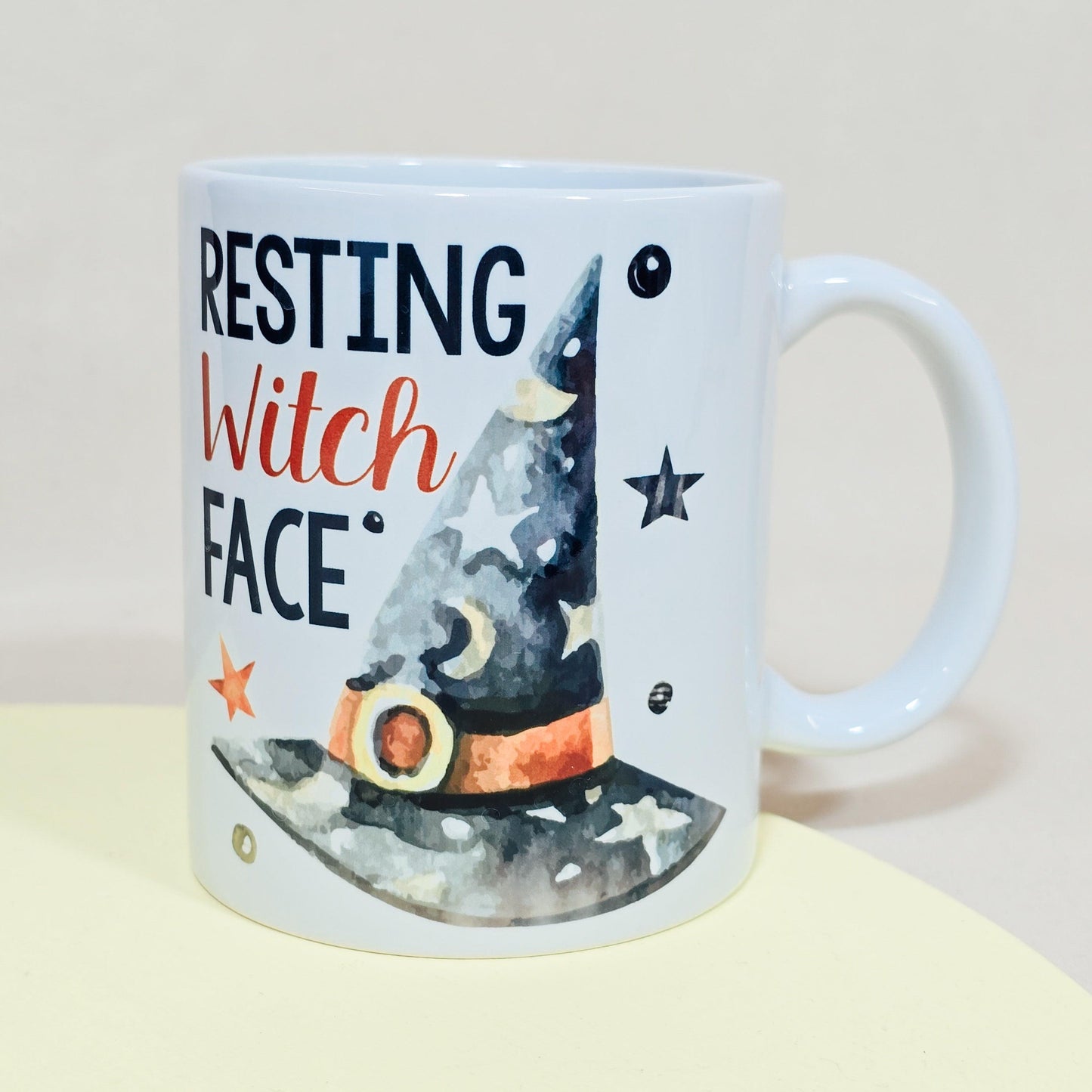 White Halloween mug with "Resting Witch Face" text and a witch’s hat design, available in 10oz, 15oz, and travel mug sizes.