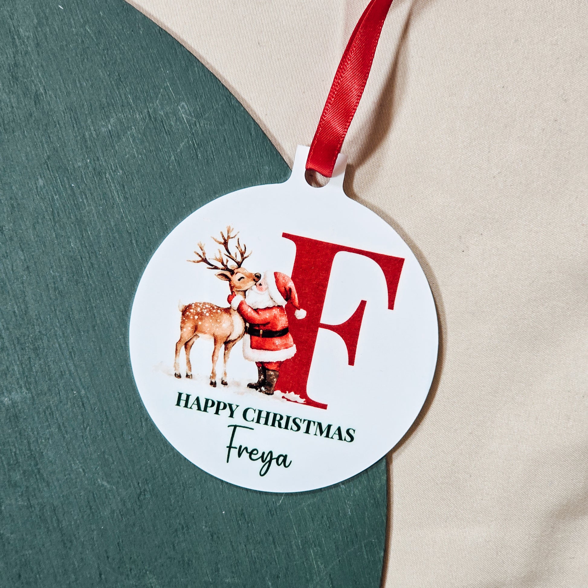 Personalised Santa bauble that says "Happy Christmas [Name]" with a large initial, perfect for festive decoration.