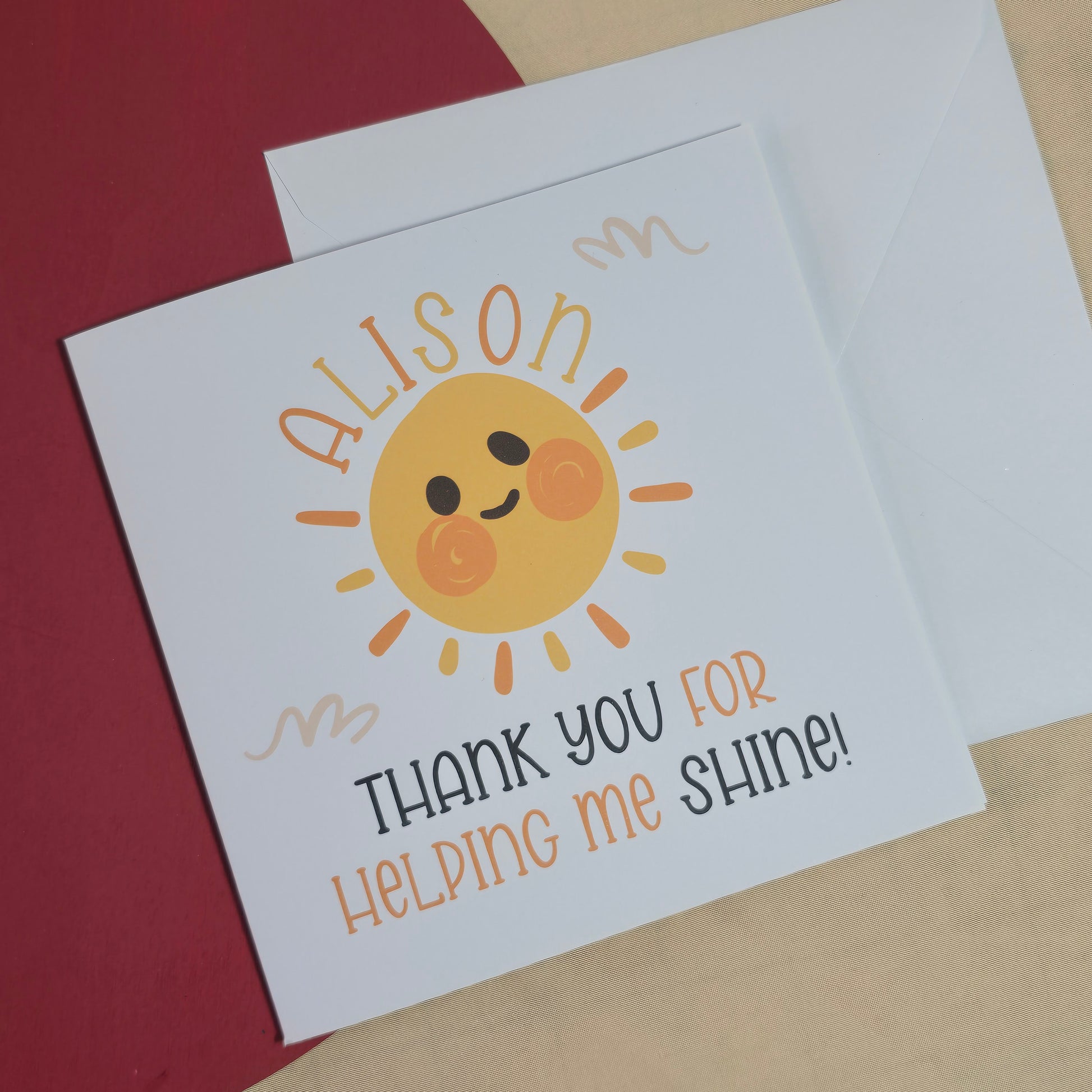Card with a sun illustration and text on a red surface