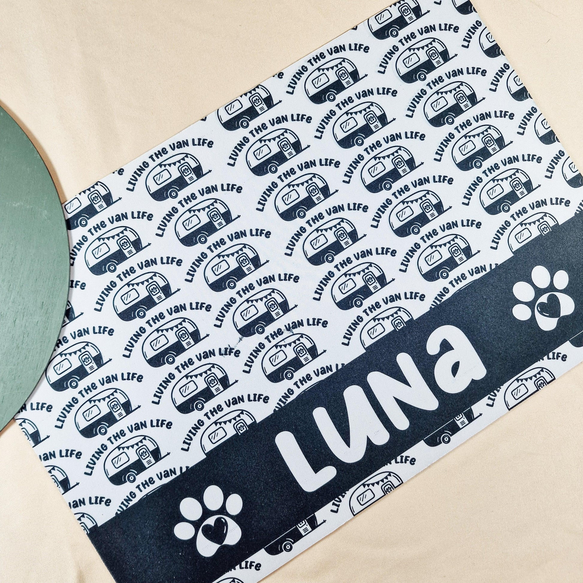 Personalised pet mat with 'Living the Van Life' and a caravan design. Features non-slip backing and custom name, size 41x27cm. Matching pet bowls available in small (12cm), medium (15cm), and large (18cm).