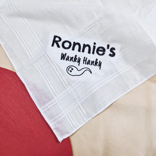 An embroidered handkerchief with the text "Names Wanky Hanky" on it. Customisable with names, this funny and unique handkerchief is perfect for a playful sex gift or humorous occasion.